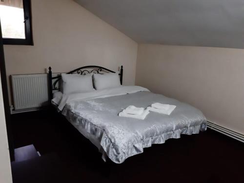 um quarto com uma cama com duas toalhas em Pensiunea Hanami em Bacau