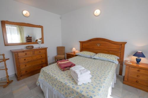 a bedroom with a bed with towels on it at Private Heated Pool, Jacuzzi & 1225m2 garden in Villa Cipreses in Frigiliana