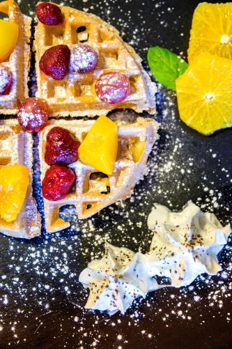 a table with some waffles with fruit on it at Qubus Hotel Kraków in Kraków