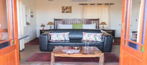 a living room with a couch and a coffee table at Ou Skool Guesthouse in Keimoes