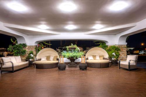 a large room with couches and tables and plants at The Volare, an Ascend Collection Hotel in San Clemente