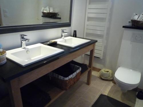 a bathroom with two sinks and a toilet at Le Logis de Miserè in Celles-sur-Belle