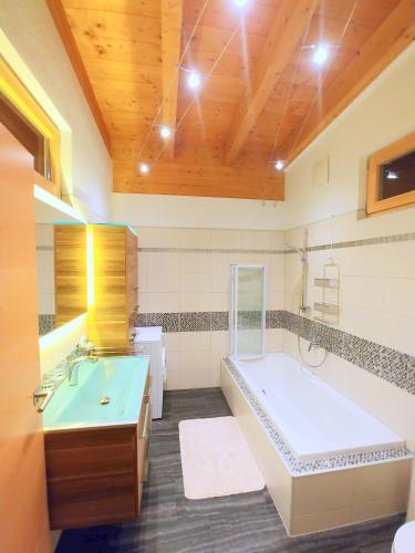 a large bathroom with a tub and a sink at Ferienwohnungen Raffler in Fieberbrunn