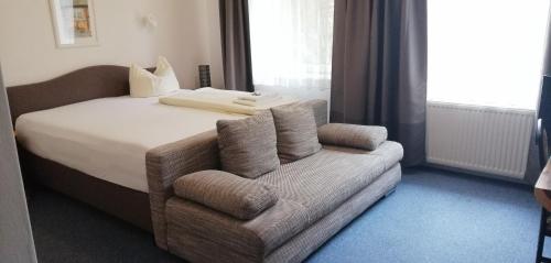 a hotel room with a bed and a couch at Hotel Holsteinische Schweiz am Dieksee in Malente
