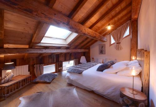 a bedroom with a large bed in a room with wooden ceilings at CHALET ALOUETTE Authentique et confortable Proche commerces et Pistes in Champagny-en-Vanoise