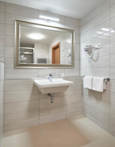 a bathroom with a sink and a mirror at Spa Hotel Devin in Mariánské Lázně