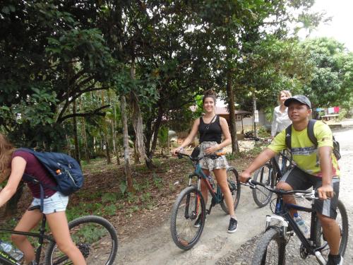 a group of people riding bikes down a dirt road at AMBOW Homestay Jungle Trekking & Village Tour in Bukit Lawang