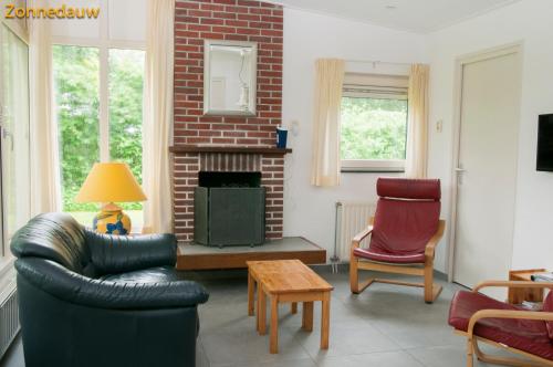 a living room with a couch and a fireplace at Zonnedauw in Kamperland