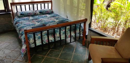 a bedroom with a bed and a couch and a window at Gap Creek Cabin in Ayton