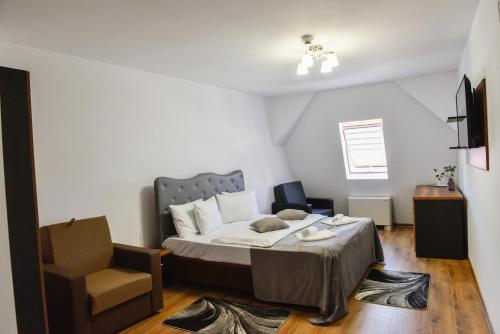 a bedroom with a bed and a chair at Hotel Darina Tarnaveni in Tîrnăveni
