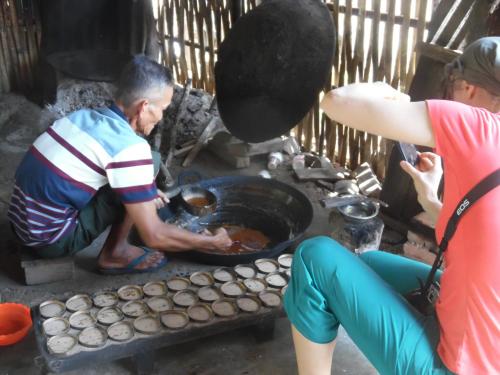 a couple of people cooking food over a grill at AMBOW Homestay Jungle Trekking & Village Tour in Bukit Lawang