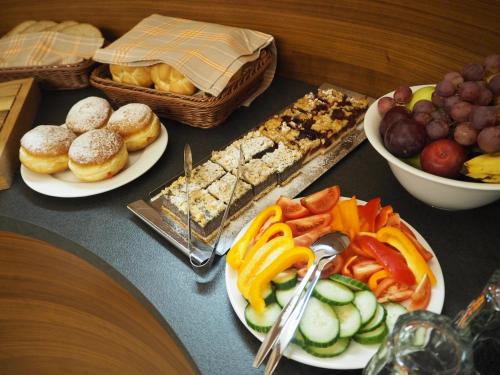 a table with plates of food and a bowl of fruit at Residence Hluboká in Hluboká nad Vltavou