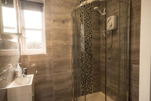 a bathroom with a shower and a sink at Riber Cottage - Darwin Lake Holiday Village in Matlock