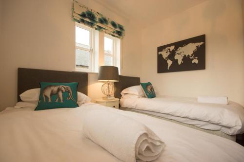 a bedroom with two beds with a horse pillow on it at Riber Cottage - Darwin Lake Holiday Village in Matlock