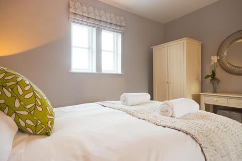 a bedroom with a white bed with two towels on it at Riber Cottage - Darwin Lake Holiday Village in Matlock