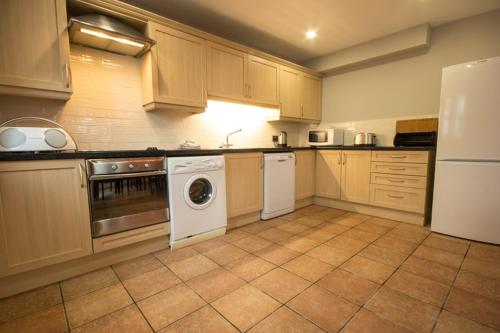 a kitchen with a stove and a washer and dryer at Riber Cottage - Darwin Lake Holiday Village in Matlock