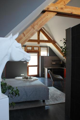Cette chambre mansardée comprend un lit et une chaise. dans l'établissement Loft dans corps de ferme - Accès jacuzzi, à Hangenbieten