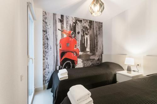 ein Schlafzimmer mit einem Bett und einem Wandbild eines roten Motorrollers in der Unterkunft Calle San Carlos 132 in Alicante