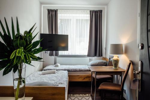 a hotel room with two beds and a desk and a table at Motelik Janowski in Szprotawa