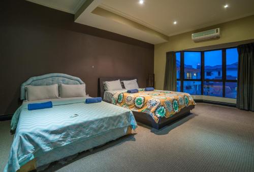 a bedroom with two beds and a large window at North Borneo Paradise@Marina Court in Kota Kinabalu