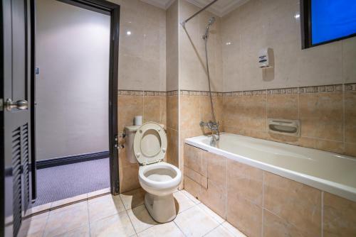 a bathroom with a toilet and a bath tub at North Borneo Paradise@Marina Court in Kota Kinabalu