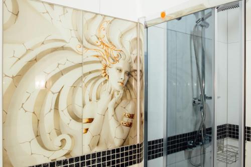 a shower stall with a painting of a woman at Motelik Janowski in Szprotawa