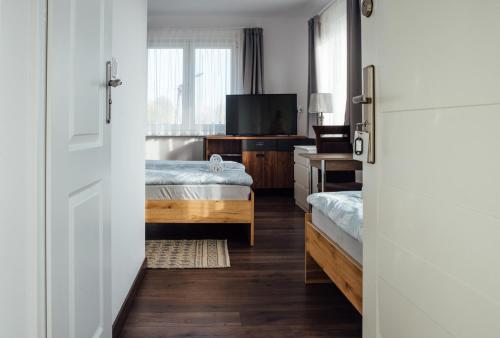 a hotel room with two beds and a television at Motelik Janowski in Szprotawa