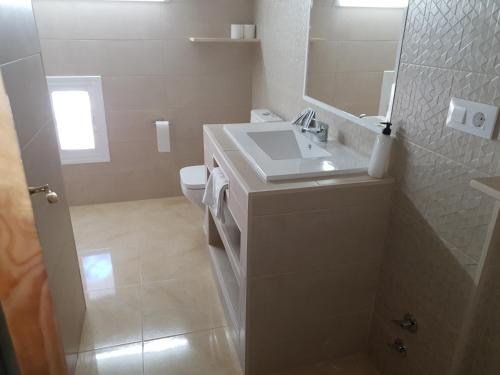a white bathroom with a sink and a toilet at Hostal Málaga in Arcos de la Frontera