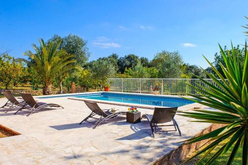 a swimming pool with three chairs and a pool at Casa Calonge in Felanitx