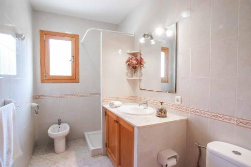 y baño con lavabo, aseo y espejo. en Villa Punta des Port Catorce en Santanyí