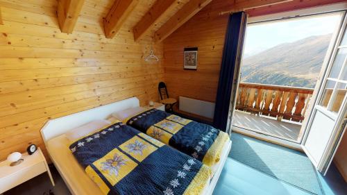 une chambre avec un lit dans une pièce avec une fenêtre dans l'établissement Andara, à Belalp