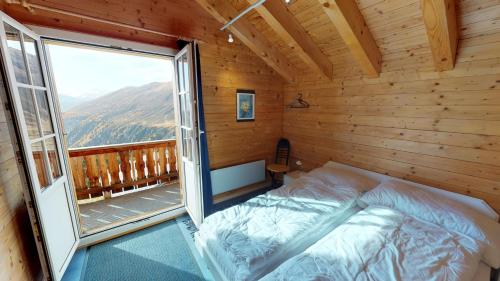 a bedroom with a bed and a large window at Andara in Belalp