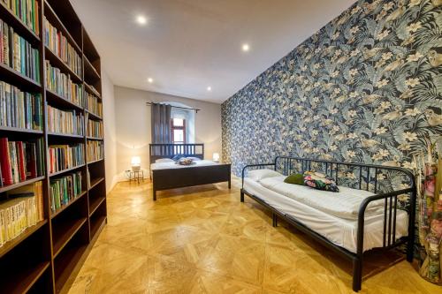 a bedroom with a bed and a wall of books at CityLife Residence in Bratislava