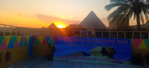 a sunset with the pyramidsowment fund bed and breakfast sign at Pyramids Overlook Inn in Cairo