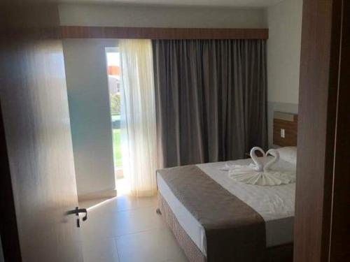 a bedroom with a bed and a large window at Eco Resort Ilhas do Lago in Caldas Novas