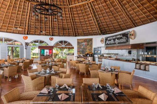 una sala da pranzo con tavoli e sedie e un ristorante di Ocean Maya Royale Adults Only - All Inclusive a Playa del Carmen