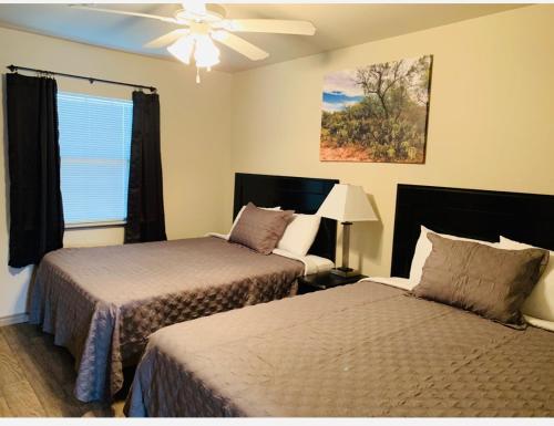 sypialnia z 2 łóżkami i wentylatorem sufitowym w obiekcie Eagle's Den Suites Andrews a Travelodge by Wyndham w mieście Andrews