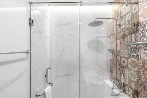 a shower with a glass door in a bathroom at ARUN Riverside Bangkok in Bangkok