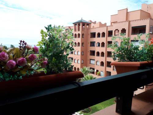 d'un balcon avec des plantes en pot et d'un bâtiment. dans l'établissement Apartamento Playa Verde, à Isla Canela