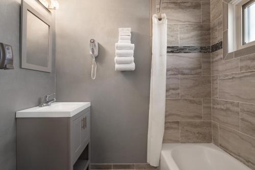 a bathroom with a white sink and a shower at Plim Plaza Hotel in Ocean City