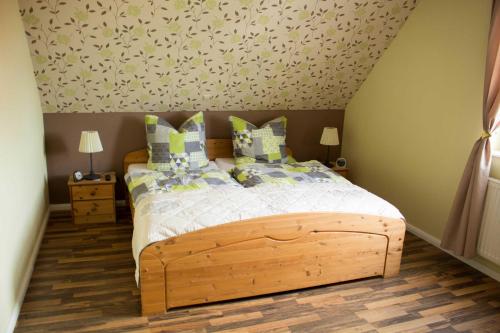 a bedroom with a bed with a wooden bed frame at Ferienhaus Moorspatz, 95143 in Rhauderfehn