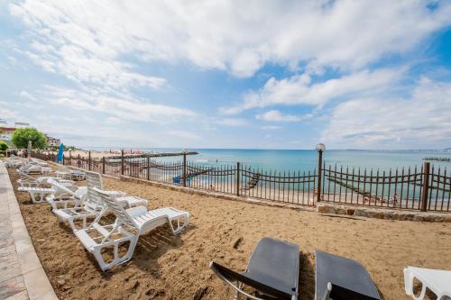 a row of lounge chairs on the beach at Messambria Fort Noks Beach Apartments in Elenite