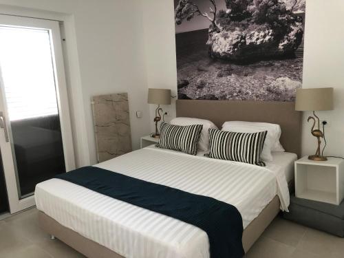 a bedroom with a bed with a painting on the wall at Villa Vodomar - Adults Only in Senj