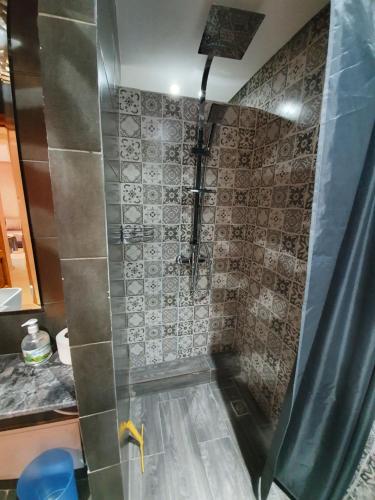 une salle de bain avec une douche avec un rideau de douche dans l'établissement Charming Marrakech Apartement, à Marrakech