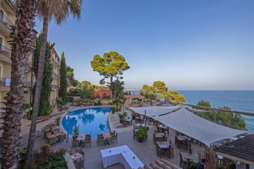 Blick auf ein Resort mit Pool und Meer in der Unterkunft Hotel Cap Roig by Brava Hoteles in Platja  d'Aro