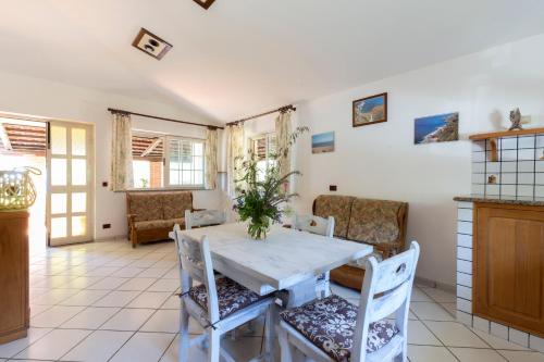 a dining room with a white table and chairs at Villa Aurelia in Ioppolo