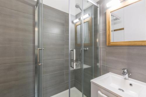 uma casa de banho com uma cabina de duche em vidro e um lavatório. em Apartment Iris 4 em Chamonix-Mont-Blanc