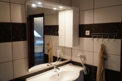 a bathroom with a sink and a mirror at Eplényi Apartmanház in Eplény