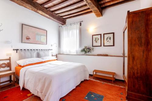 Un dormitorio con una gran cama blanca y una ventana en Agriturismo Apparita, en Montecastelli