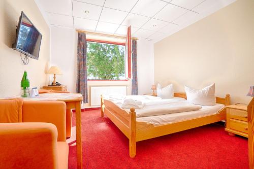 a bedroom with two beds and a window at Hotel am Gothensee in Heringsdorf